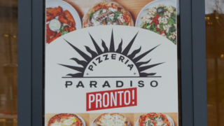 Poster on business door highlighting Pizzeria Paradiso Pronto coming soon with photos of pizzas.