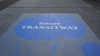 Blue decal on sidewalk with Future Transitway text.